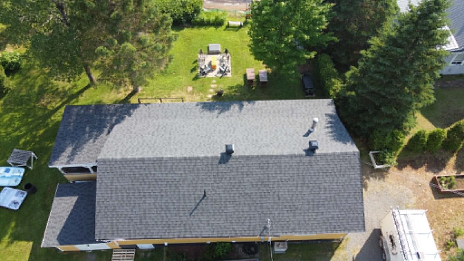 Toiture neuve en bardeaux noirs deux tons, maison avec jardin