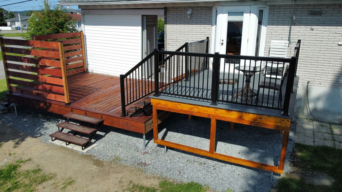 Patio en bois neuf avec pergola et rampes noires