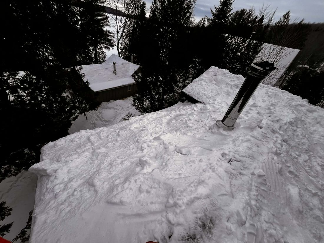 Déneigement d'une toiture résidentielle enneigée