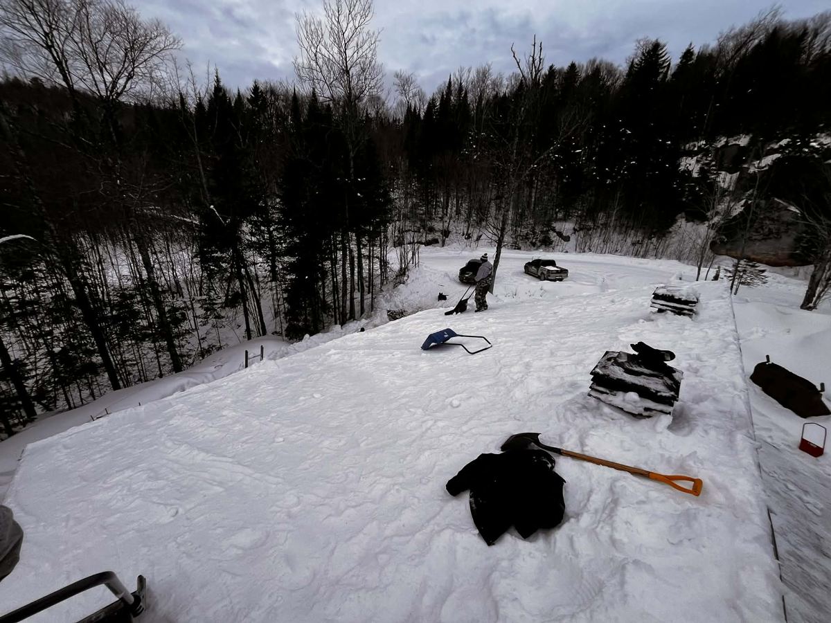 Déneigement d'une toiture enneigée en Mauricie, pelle et neige dégagée